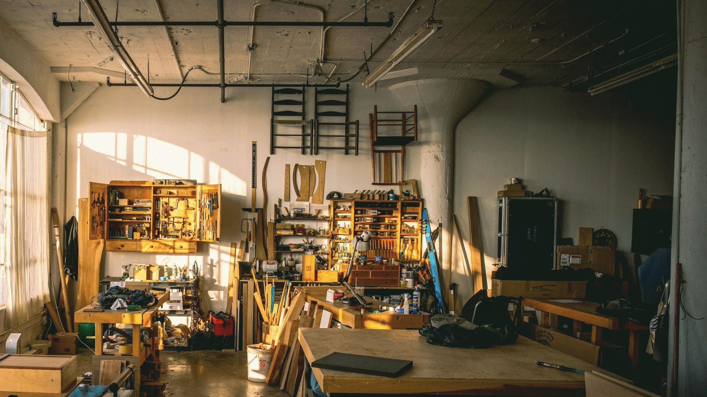 L’atelier en fin de journée : établis, machines et bois en attente.