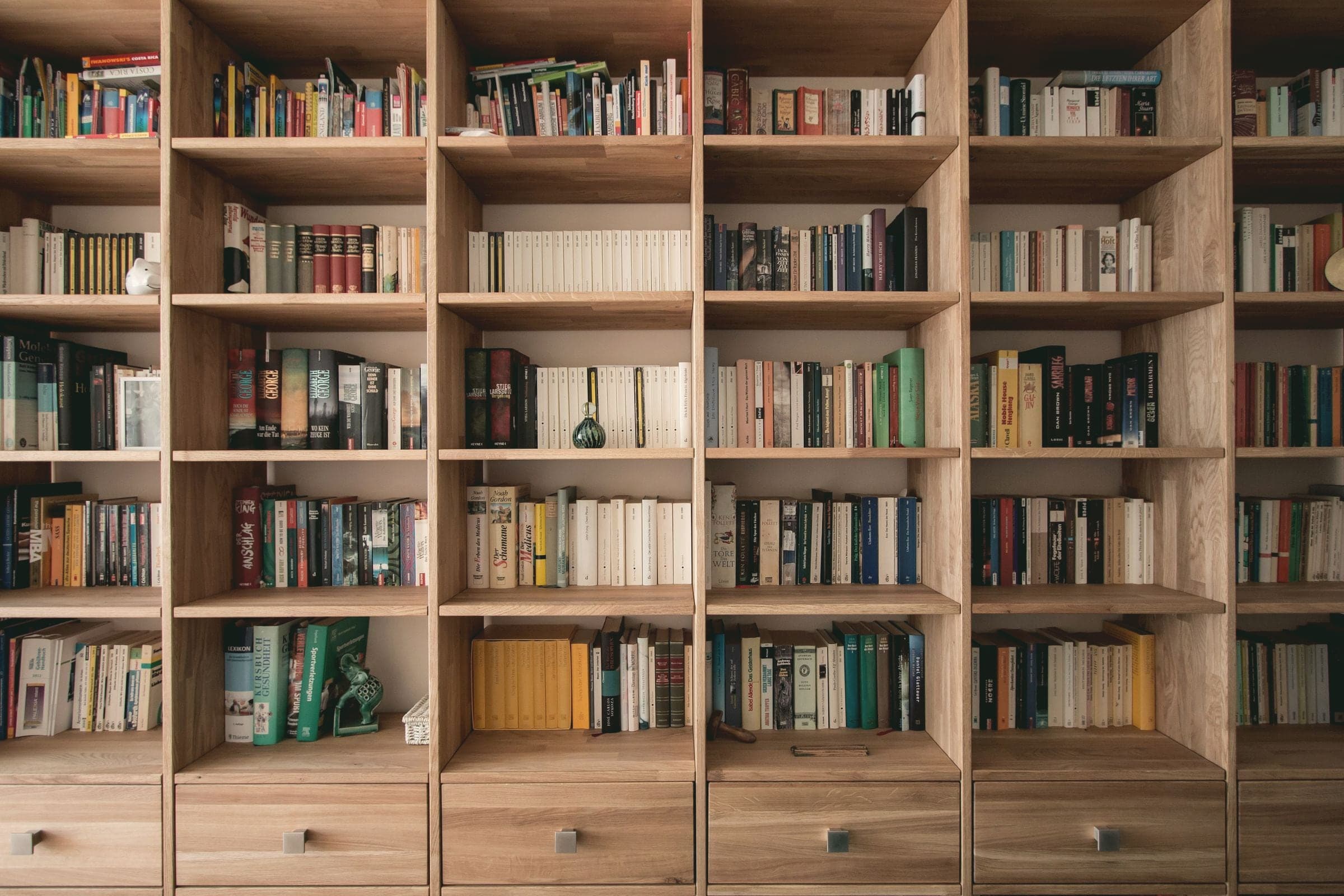 Bibliothèque en chêne couvrant tout un mur, tiroirs en partie basse.