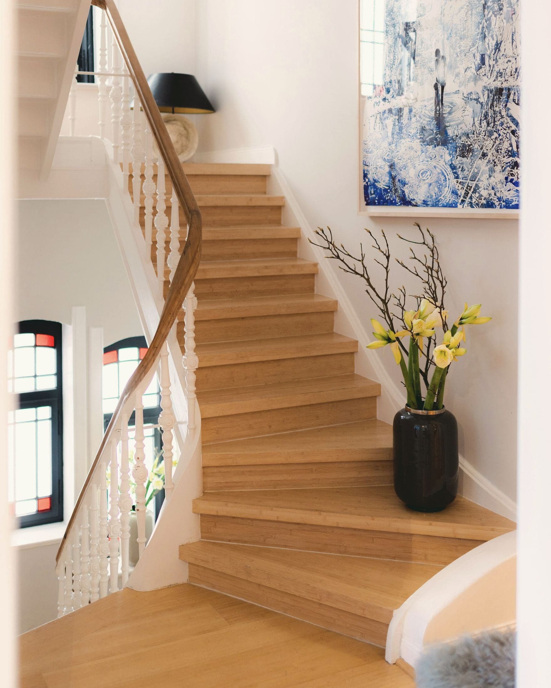 Escalier quart tournant en chêne, balustres blancs et main courante en bois.